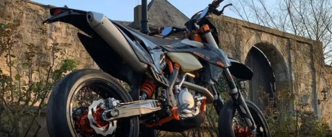 KTM EXC als Supermoto vor einer alten Steinmauer, Titelbild der Facebook-Gruppe